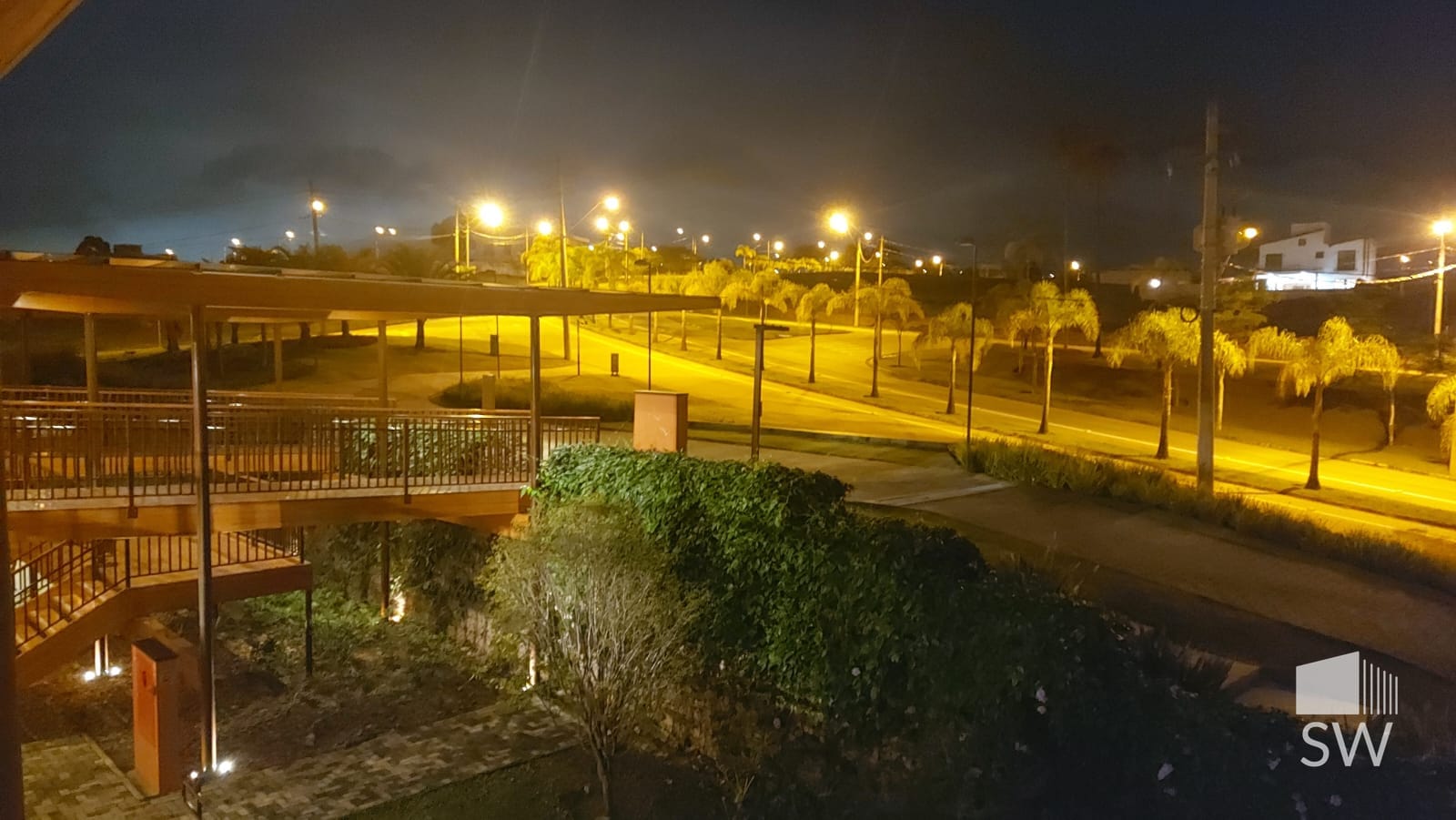 Vista noturna das ruas internas arborizadas (área comum do condomínio)
