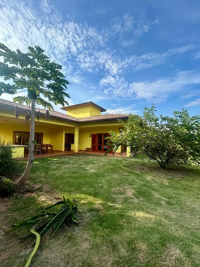 Vista dos fundos: varanda com área gourmet, jardim e pomar
