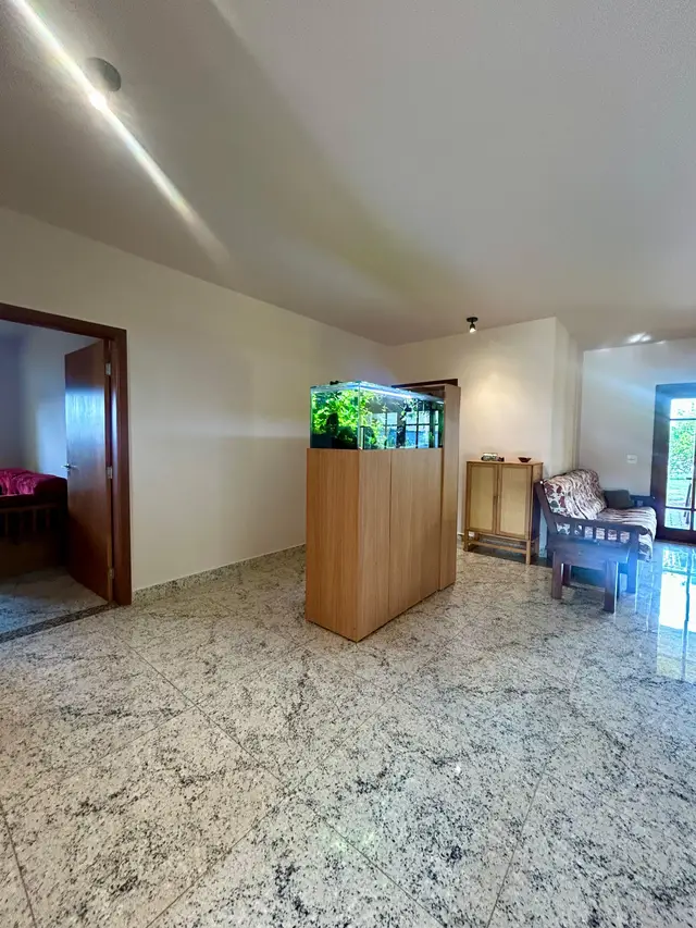 Sala de estar com piso em granito e aquário embutido