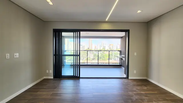 Sala de estar e jantar integrada, com portas de vidro para o terraço e vista aberta para a cidade